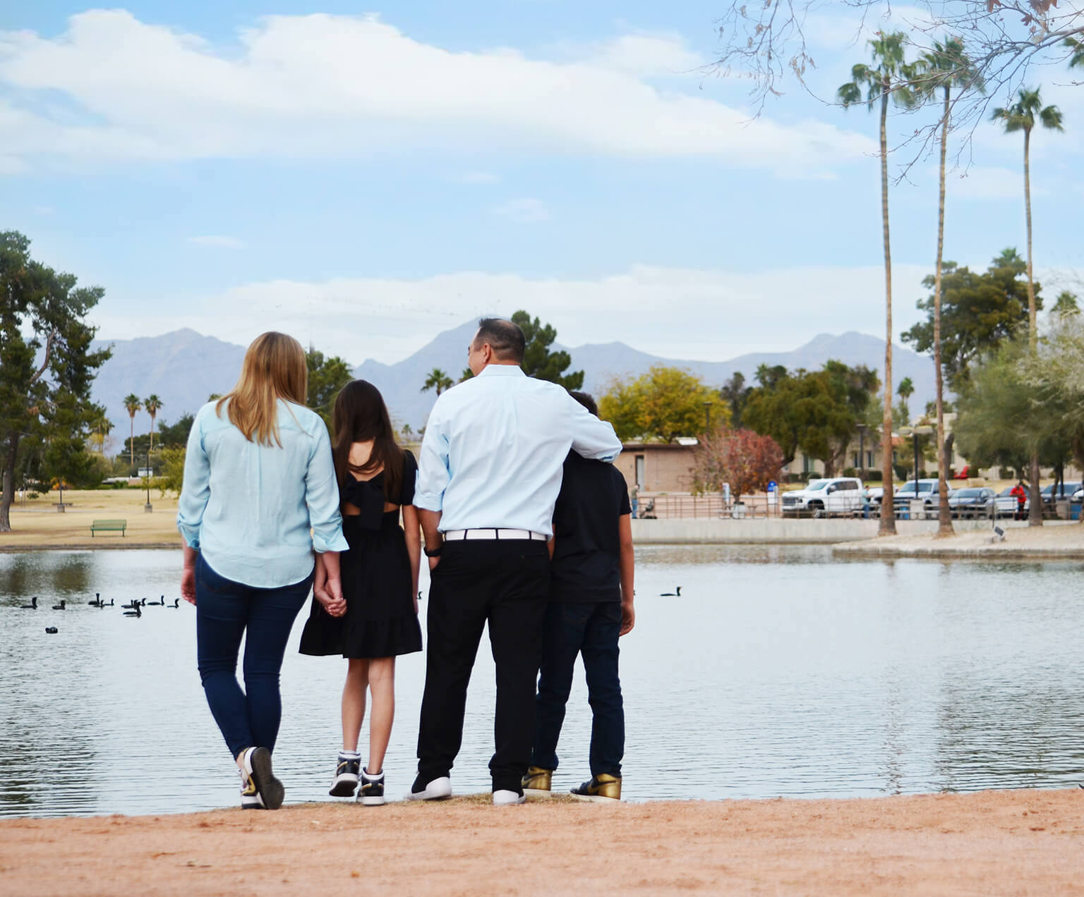 Brian and his family with their arms around each other taken from behind